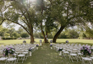 red horse bnb outdoor ceremony trees purple white florals aisle elise almendarez 300x208